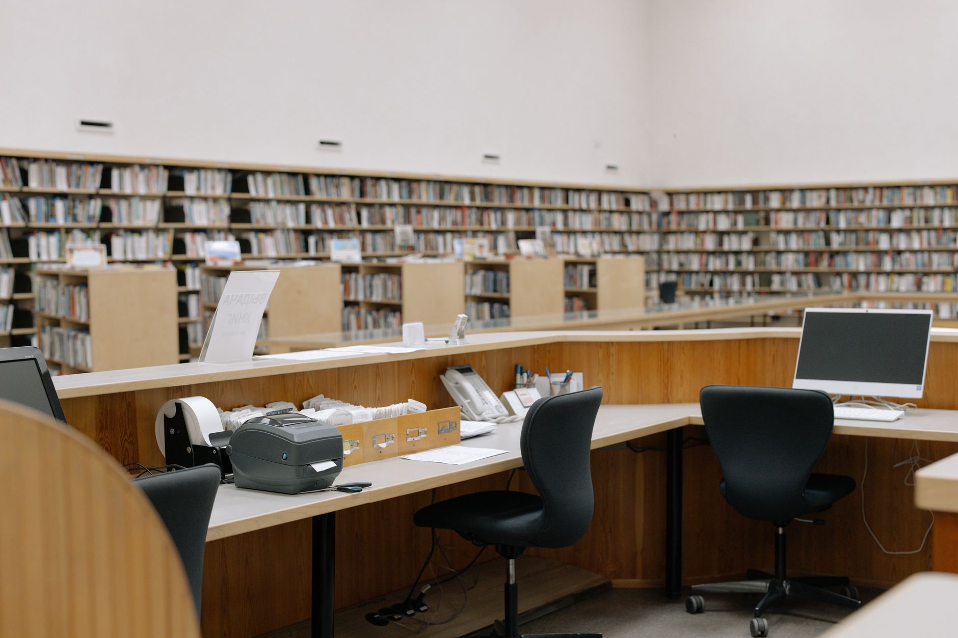 a research office interior with large monitors displaying satellite imagery and aerospace charts, bookshelves lined with military doctrine publications, no people as focal point