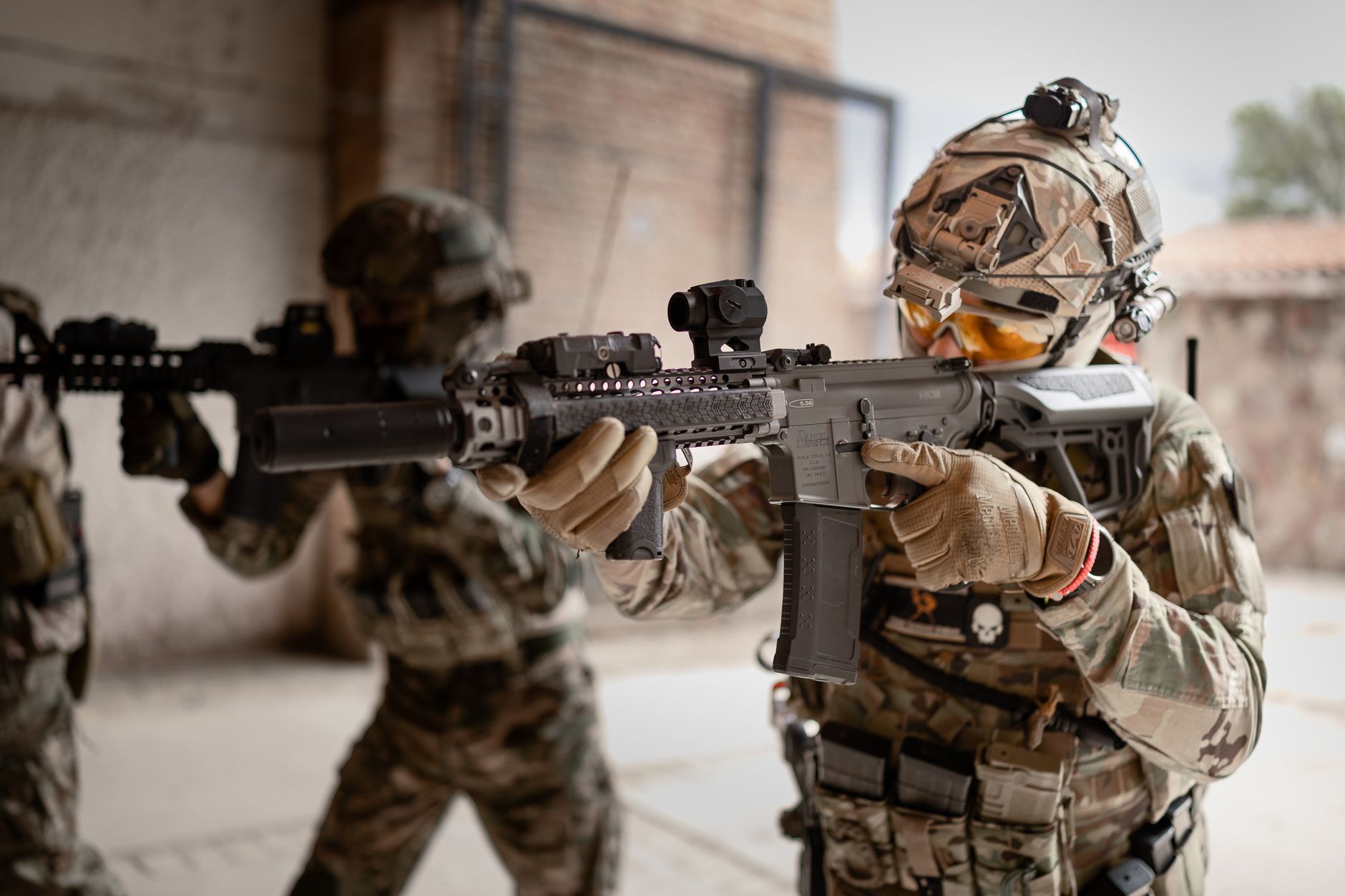 an Air Force security forces airman in uniform conducting weapons qualification training on an outdoor pistol range, target lanes visible in the distance