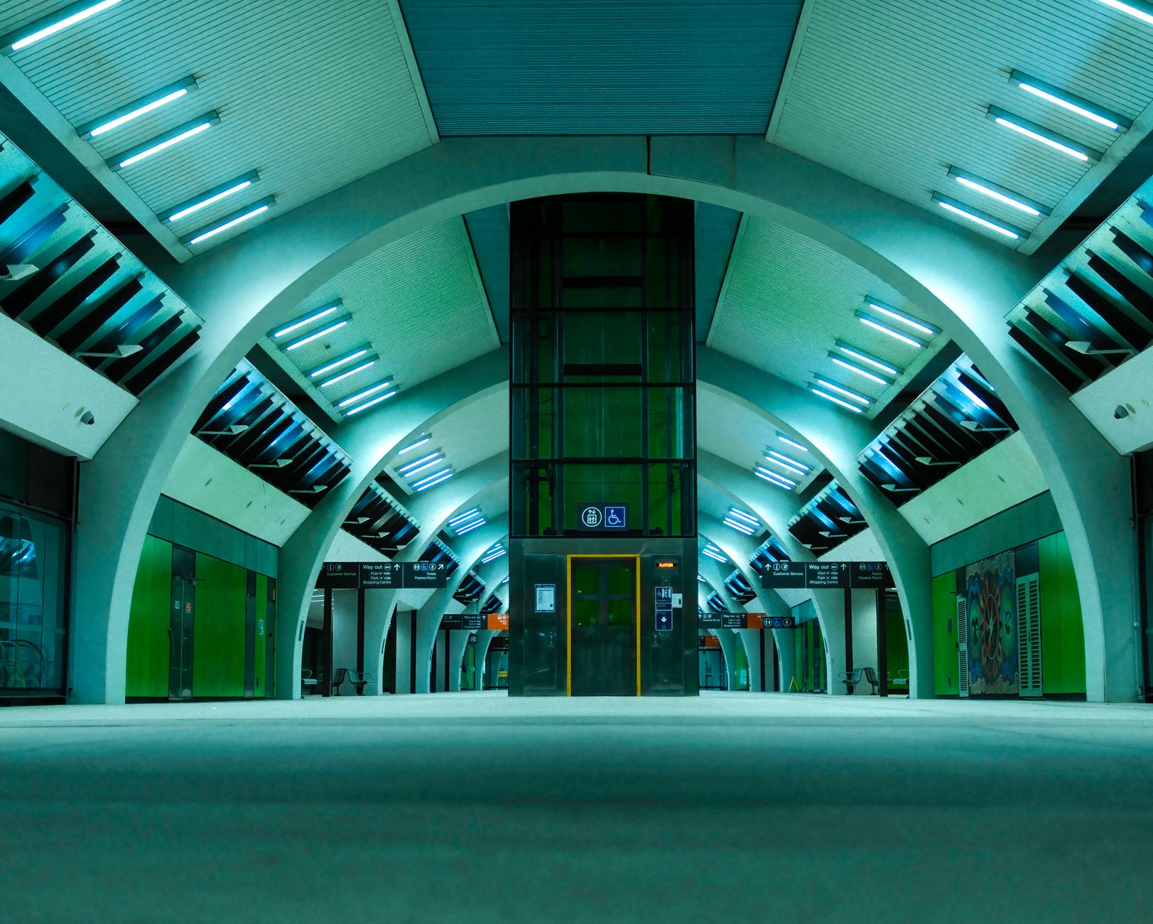 a biometric scanning kiosk in a modern government facility lobby, empty hallway visible in background, fluorescent lighting overhead