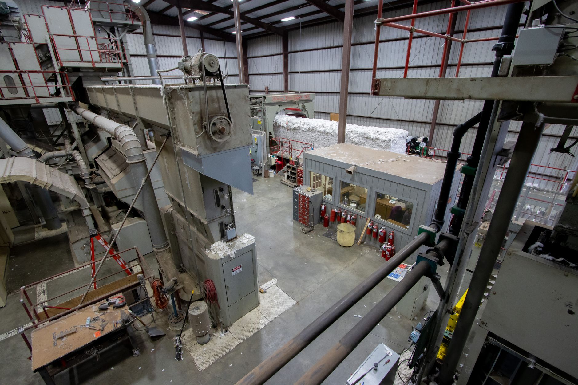rows of military sensor units on a production floor inside a defense manufacturing facility, with assembly equipment and overhead lighting visible