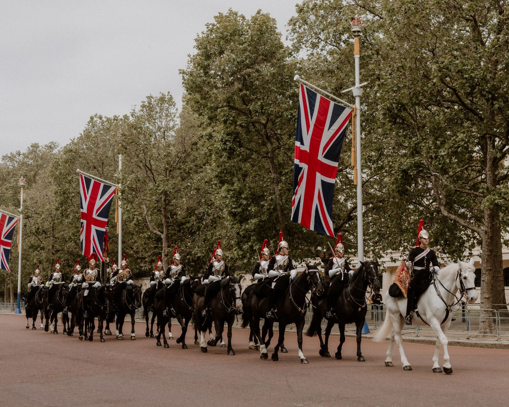 exterior of Buckingham Palace forecourt with ceremonial guards in formation, viewed from a wide angle with the palace facade as the focal point