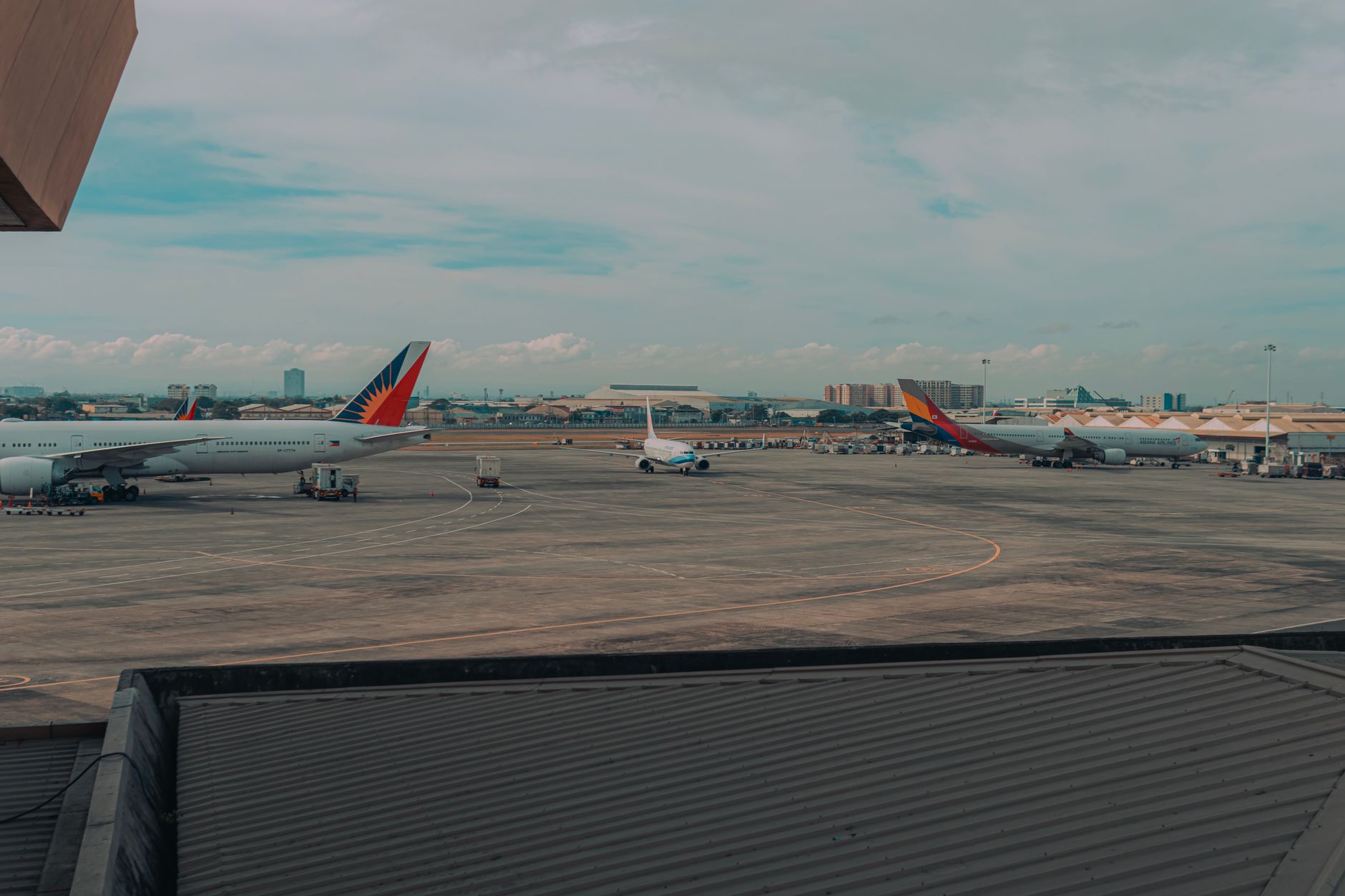 a large air base flight line photographed from above, showing dispersed aircraft parked in hardened shelters across a wide tarmac, no personnel visible as focal point