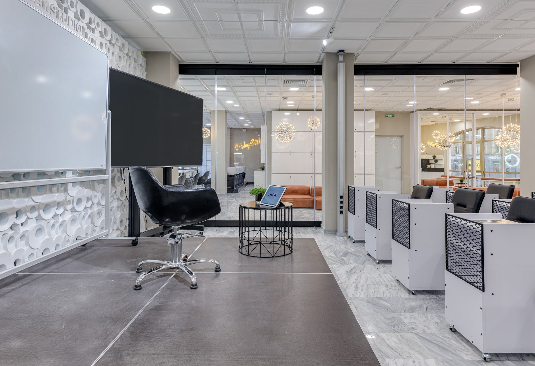 a startup accelerator demo day event space with rows of presentation screens displaying data dashboards, no individuals visible as focal subjects, chairs arranged before a stage in a modern conference facility