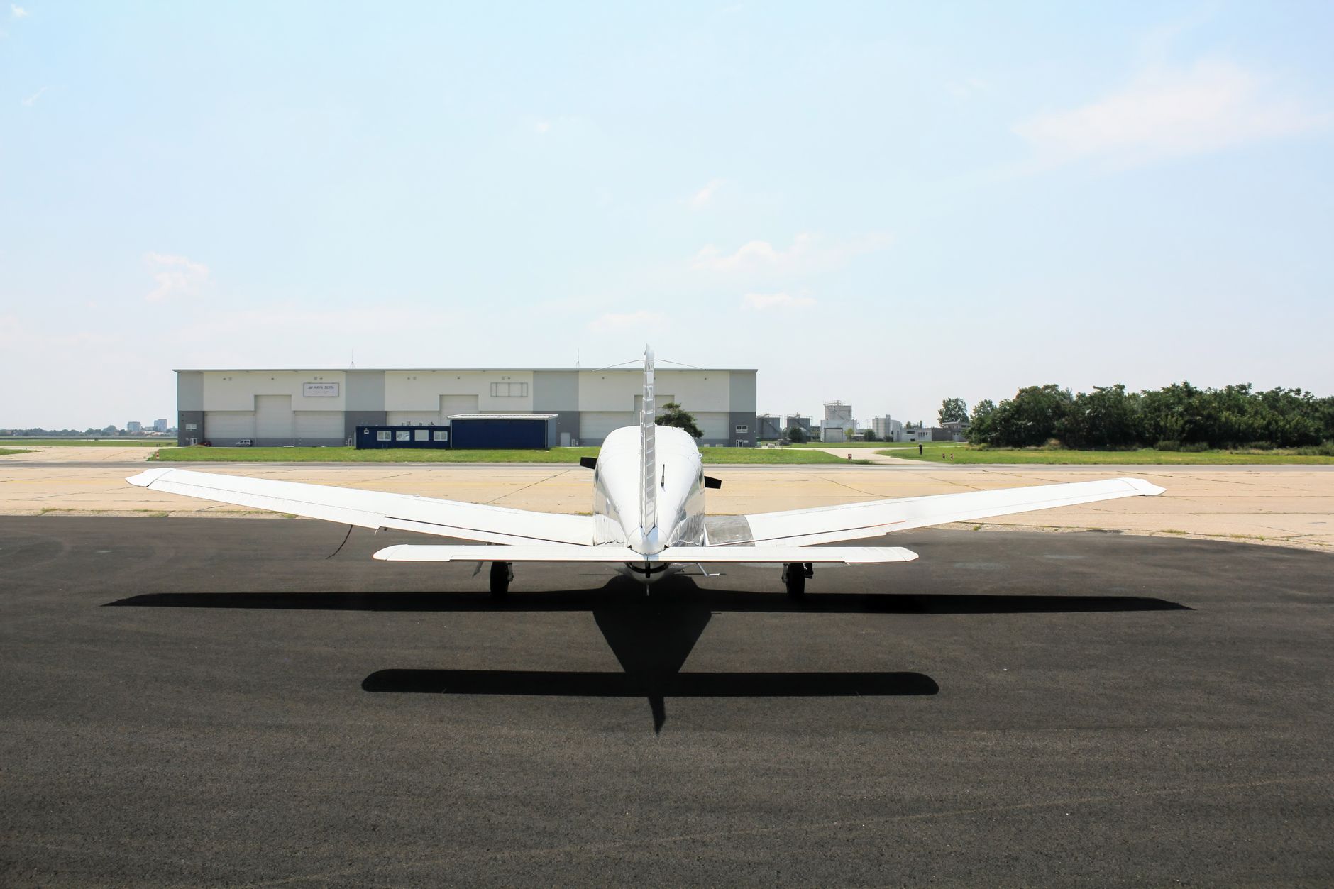 Overhead satellite view of a Chinese military airfield showing a large unmanned aircraft parked on an apron near a hangar complex