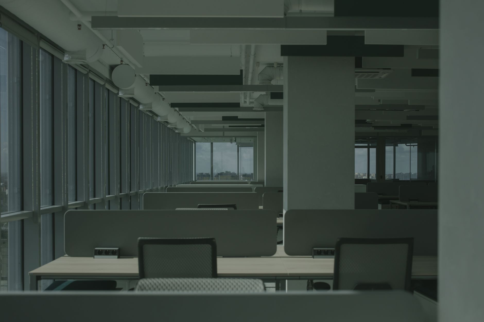 a modern open-plan technology office interior with server racks and workstations visible in the background, empty of people, natural light coming through large windows