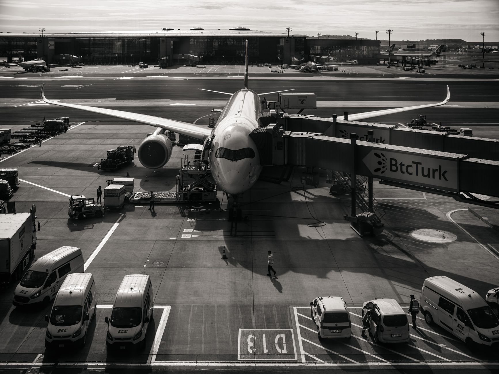 a large four-engine Antonov An-124 cargo aircraft on a tarmac at a cargo terminal, ground support vehicles visible nearby