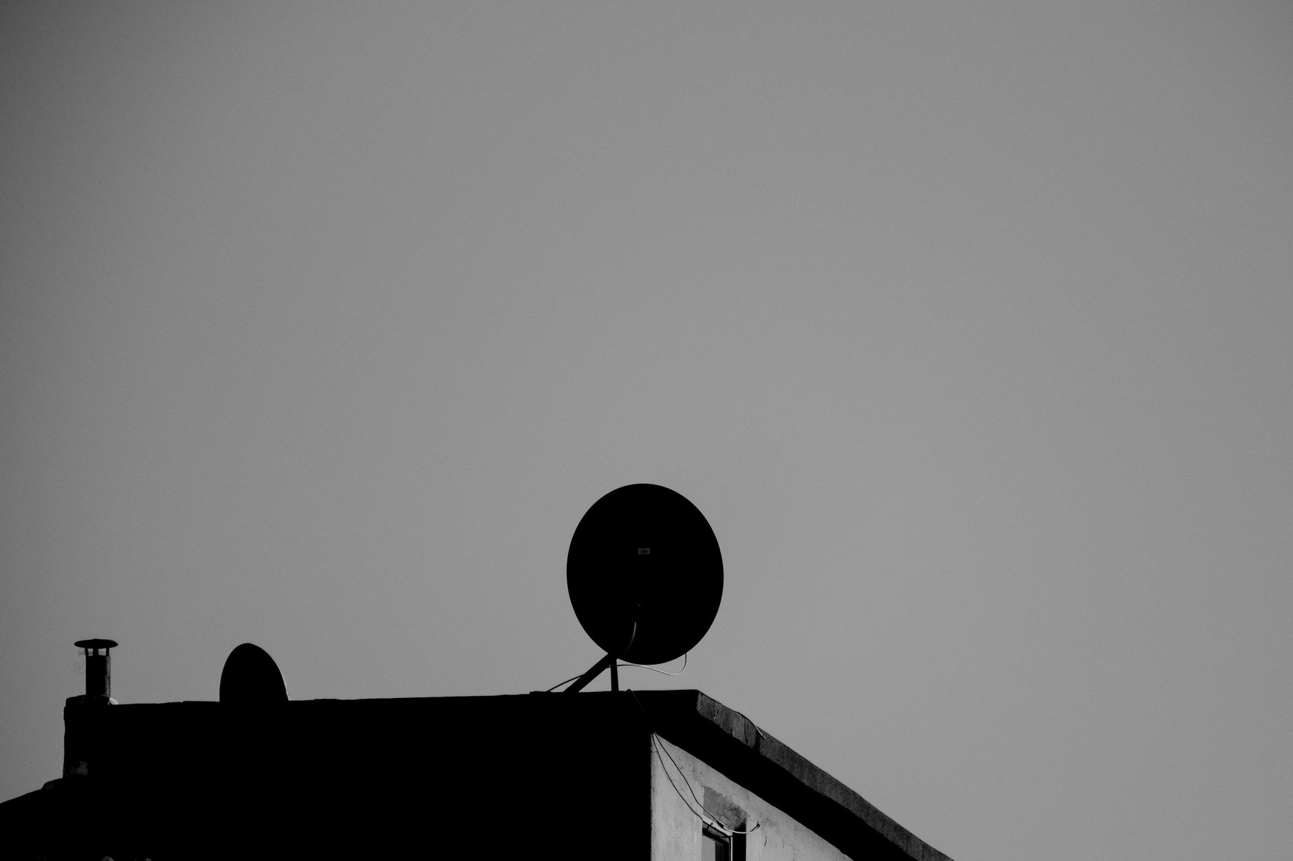 an Israeli technology office park building exterior with satellite dishes and security infrastructure visible on the roofline, shot at ground level