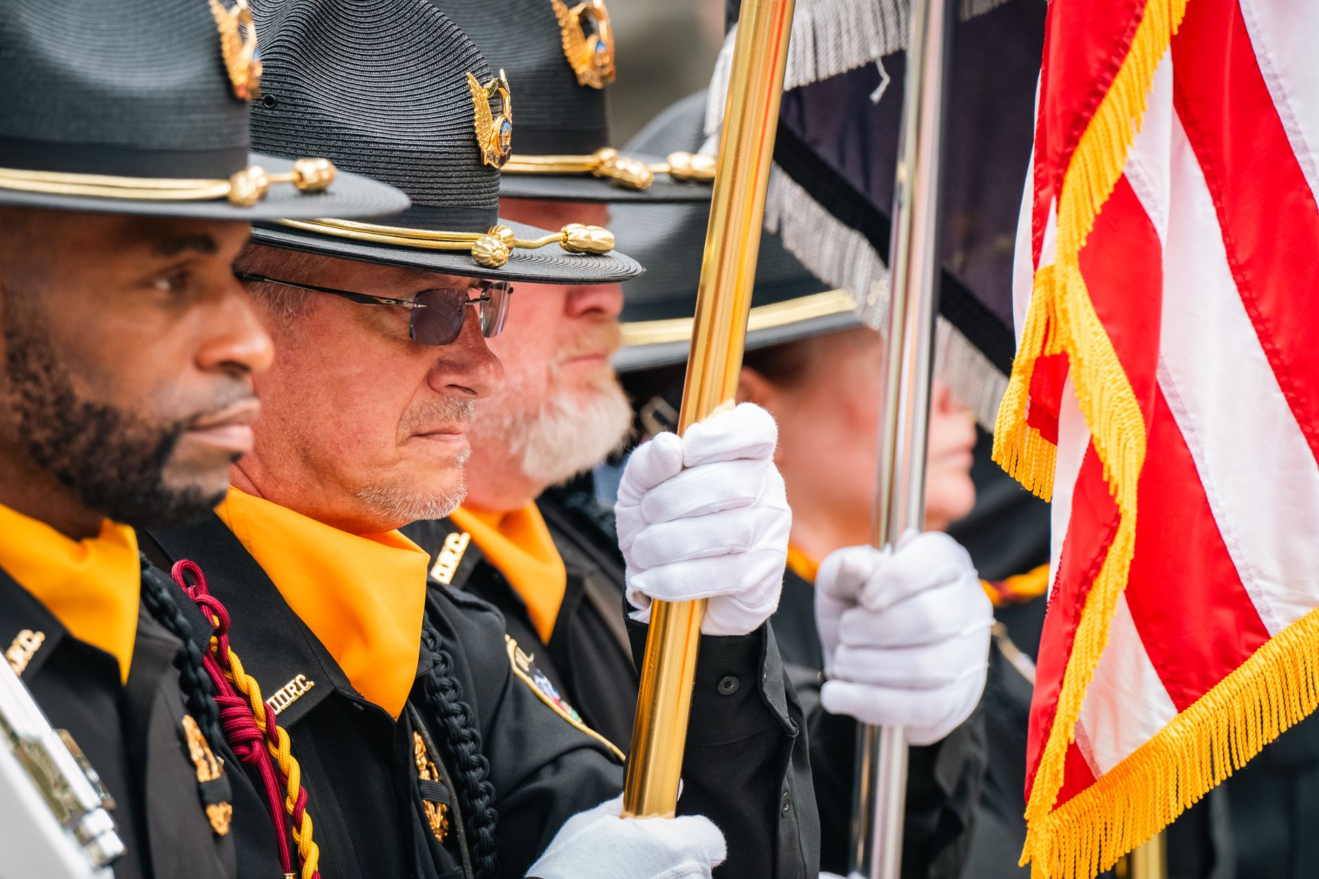 the White House South Lawn prepared for a formal state arrival ceremony, with rows of military honor guard members in dress uniforms flanking a red carpet, the Rose Garden visible in the background