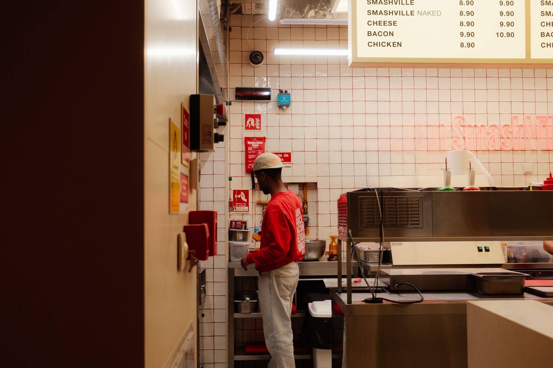 interior of a fast-food restaurant dining area with clean tables, menu boards lit overhead, and a counter visible in the background