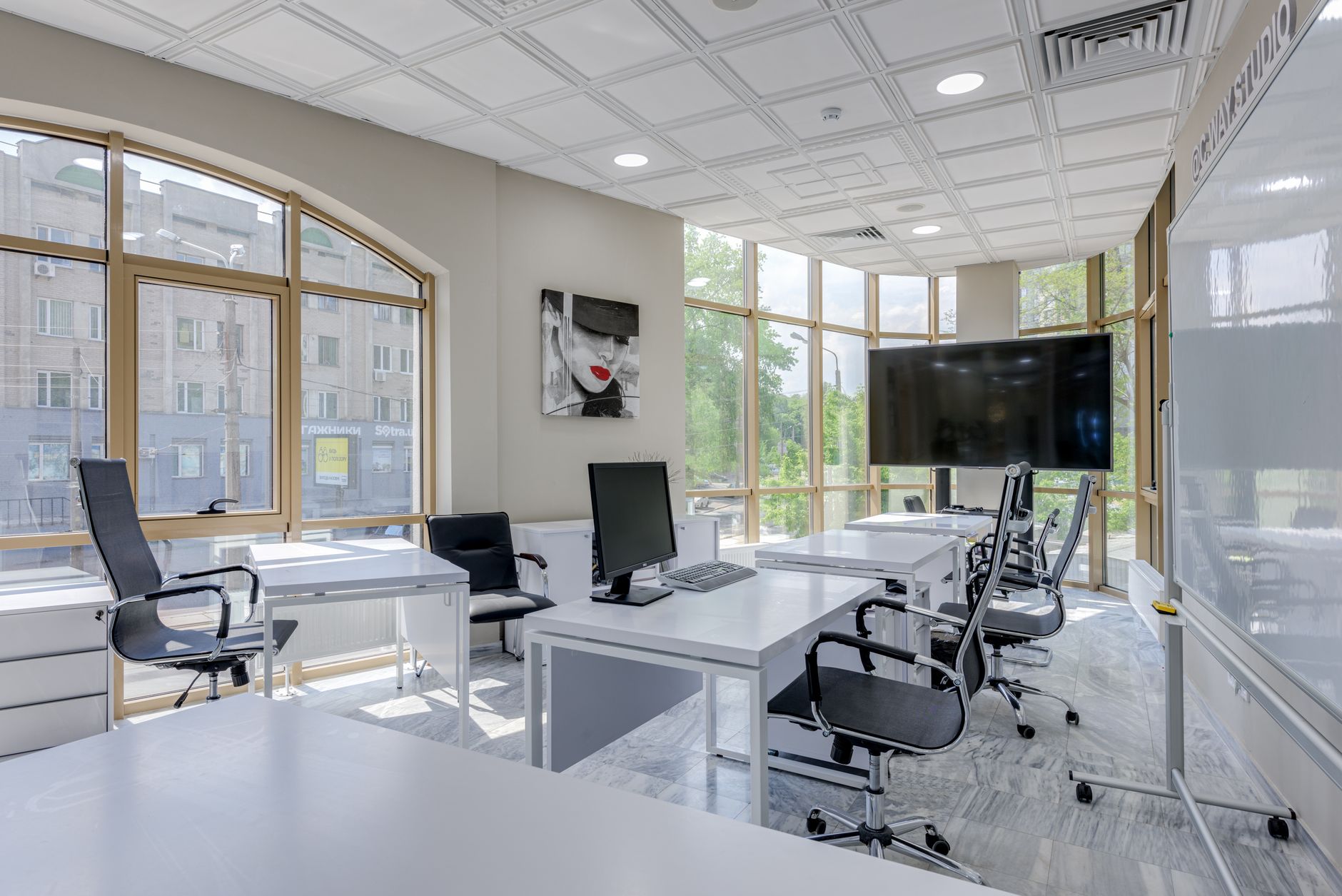 a glass-walled conference room in a modern tech office building with server rack equipment visible through an interior window in the background