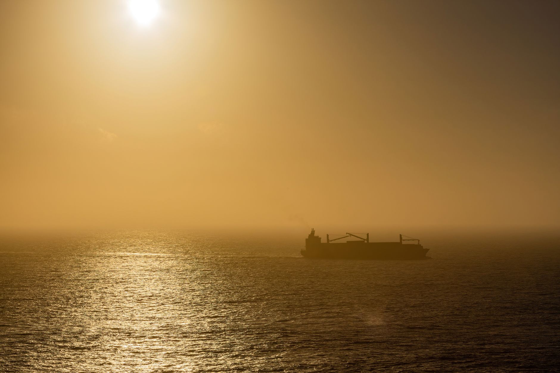 a commercial supertanker anchored offshore in calm open-ocean conditions, with no coastal features visible, illustrating extended voyage conditions