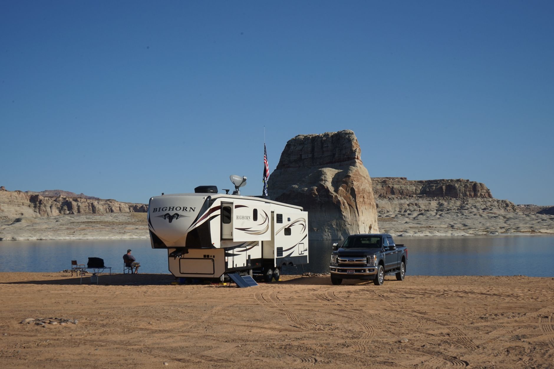 a long-range cruise missile on a mobile ground launcher in an open desert test range, with support vehicles and instrumentation trailers in the background