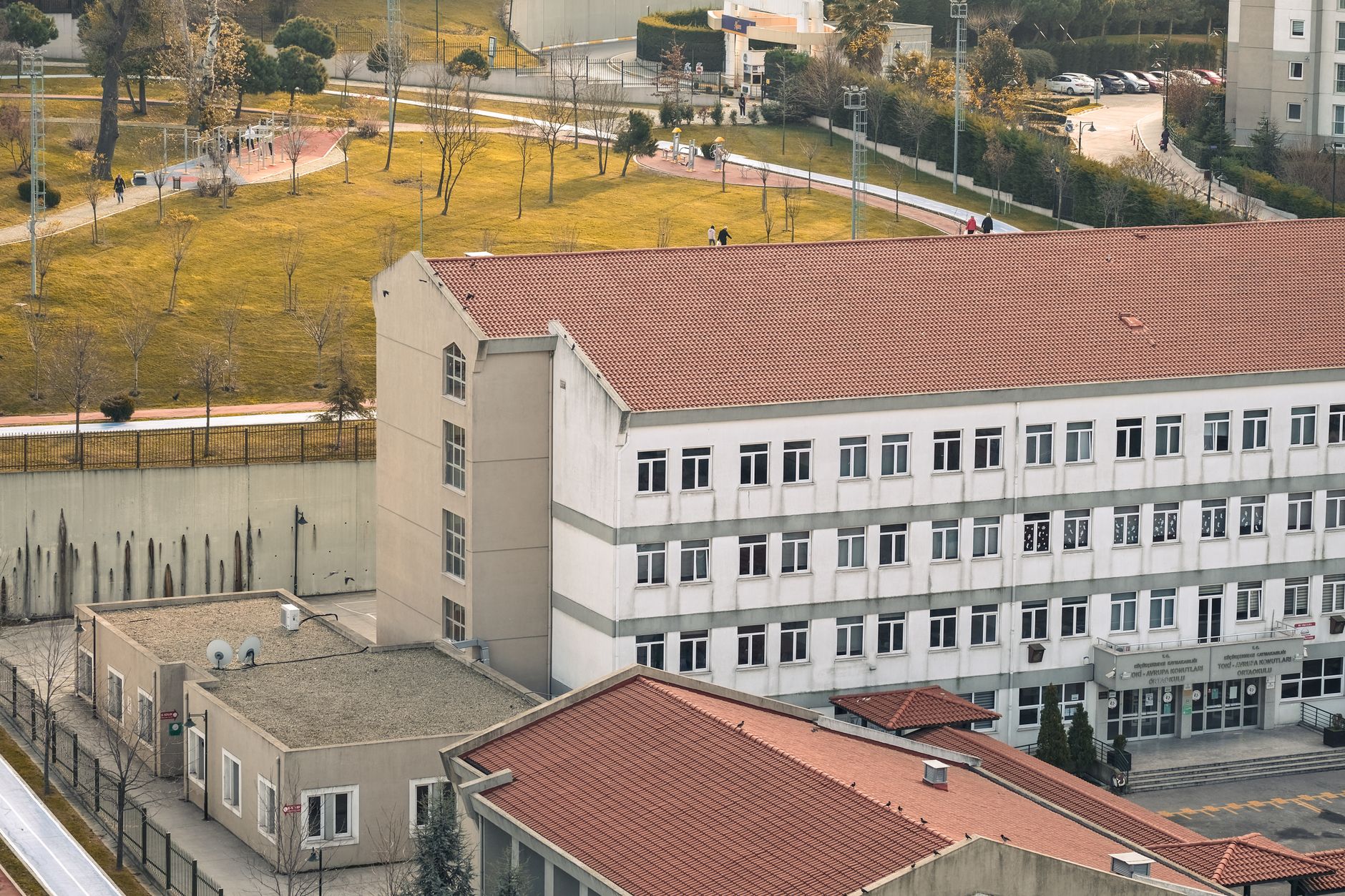 an aerial view of a military academy campus with academic and administrative buildings, parade grounds, and surrounding landscape visible in early morning light