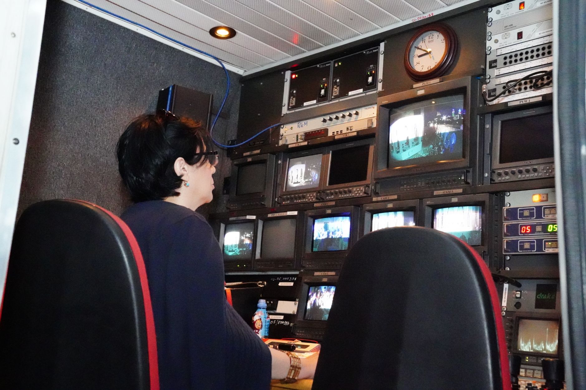 a satellite ground station or remote operations facility interior with monitoring screens displaying map overlays, no personnel as focal point