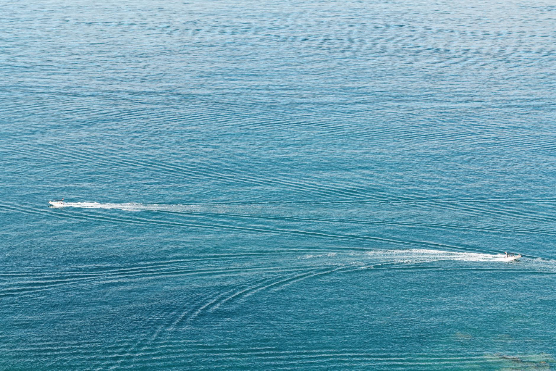 a U.S. Navy aircraft carrier strike group underway in open blue water, viewed from above at a wide angle, no text or markings visible