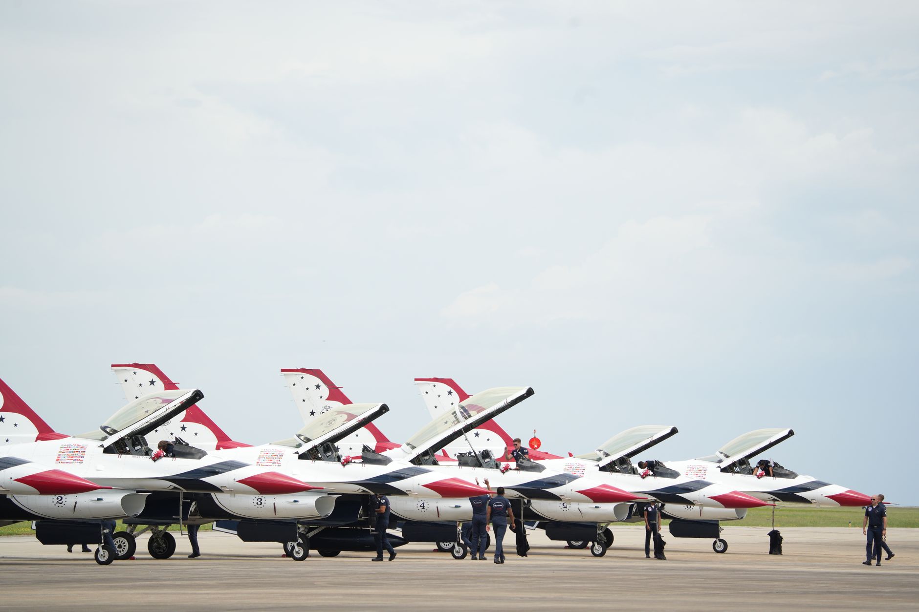 an aerial view of a U.S. Air Force flight line with multiple strike aircraft parked in revetments at a Pacific region air base, no personnel in foreground