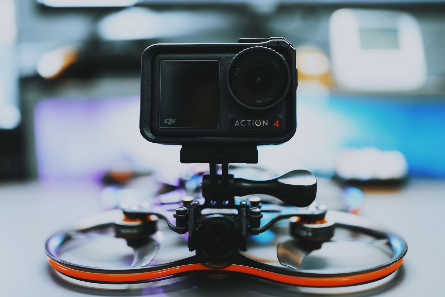 a compact quadrotor drone mounted on a display stand inside a modern technology exhibition hall, with trade-show lighting and blurred booth signage in the background
