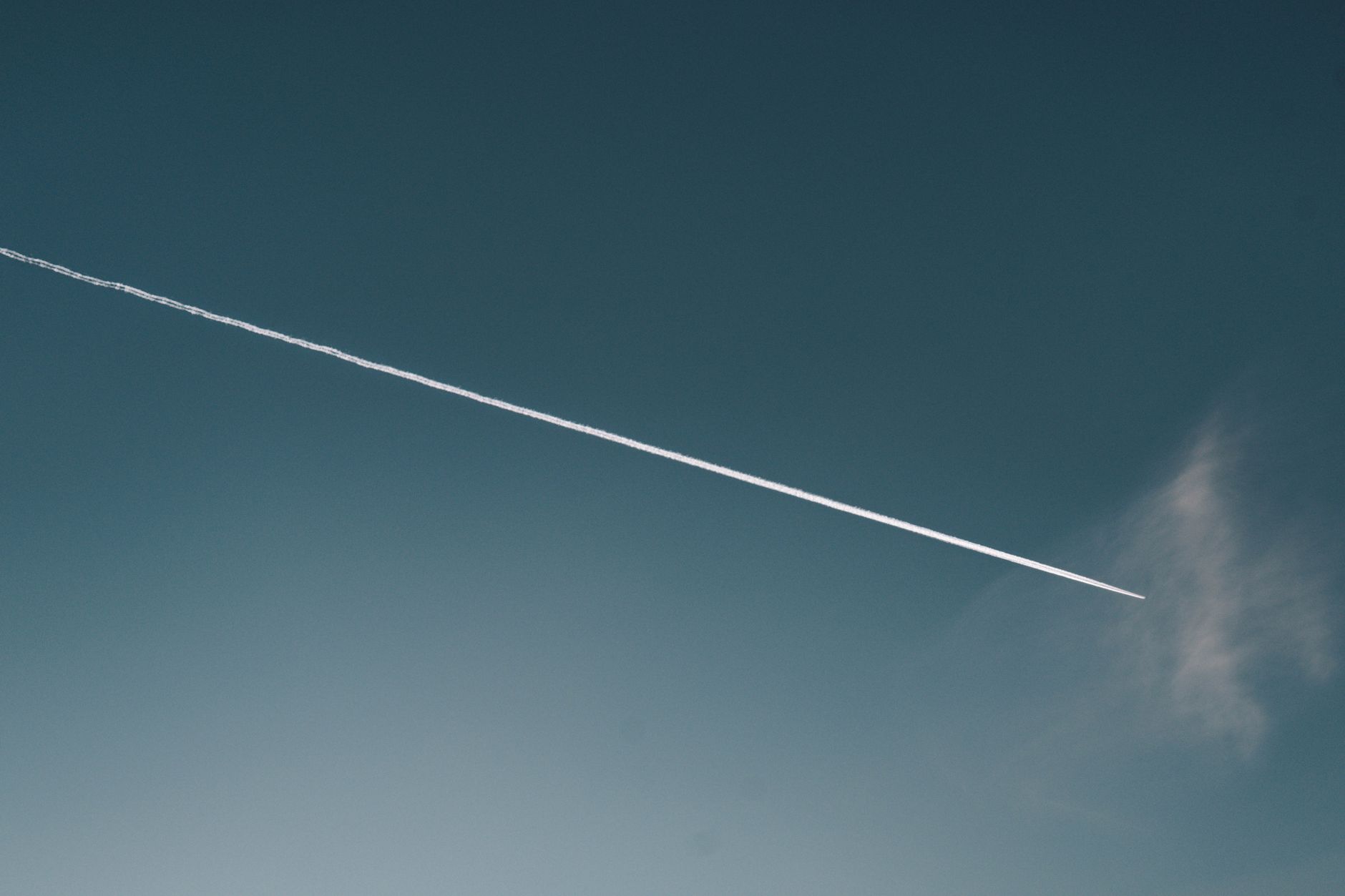 a high-altitude stratospheric balloon with sensor payload gondola suspended beneath it against a dark blue upper-atmosphere sky, wide shot showing curvature of Earth below