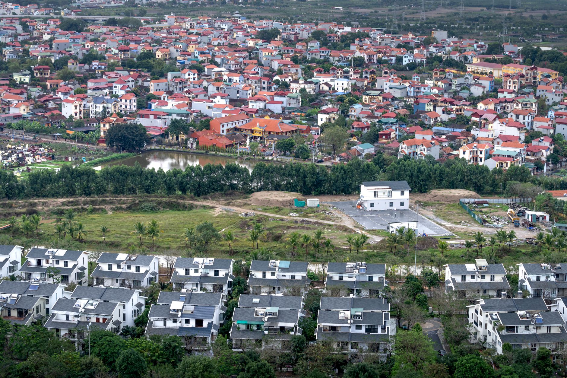 aerial view of a newly constructed military training compound with parade grounds and low administrative buildings surrounded by dense jungle terrain