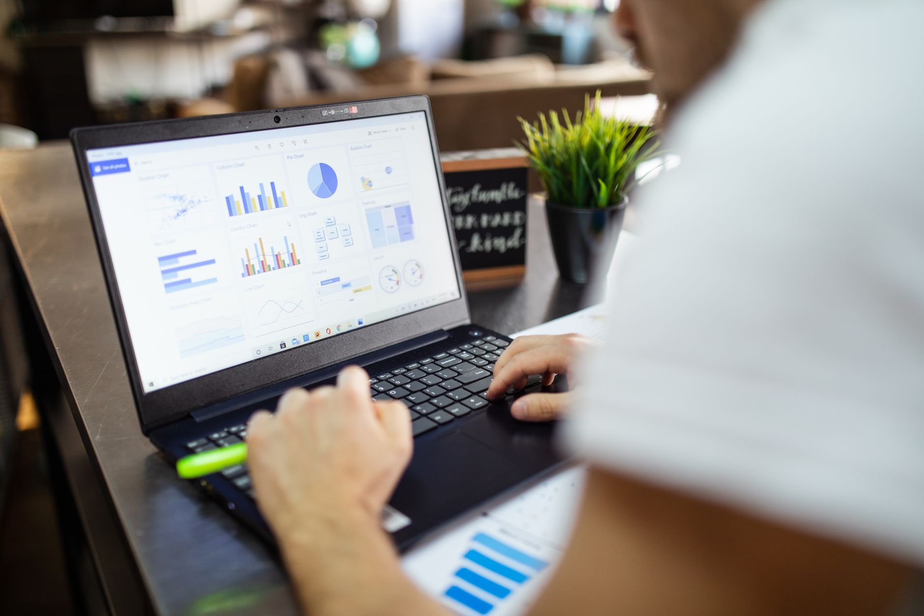 a row of laptop screens displaying spreadsheets and statistical graphs in a modern analytics office environment, no identifiable faces visible