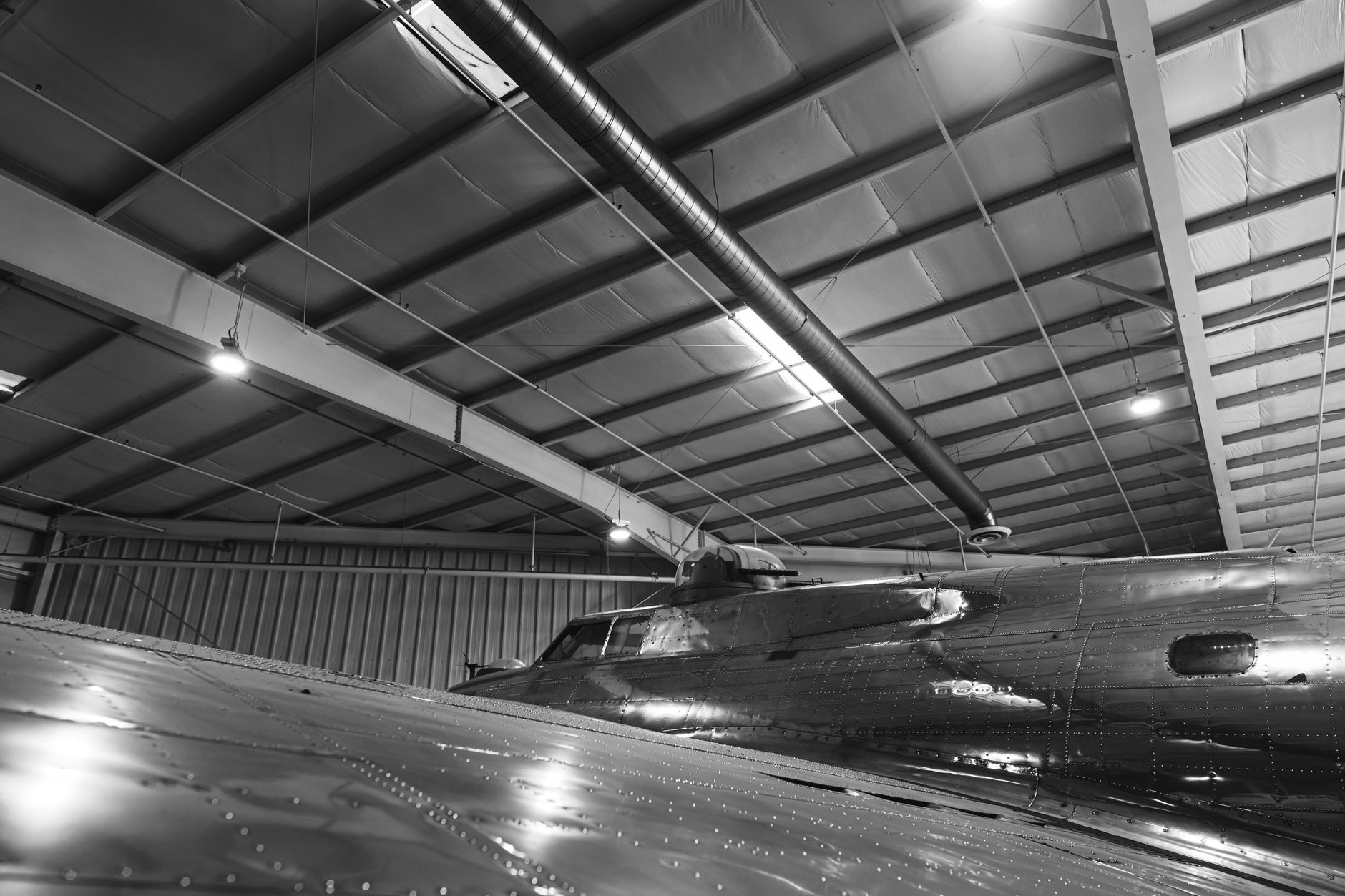 a retired SR-71 Blackbird airframe in a large aviation museum hangar, viewed from a low angle showing its distinctive chined fuselage and engine nacelles