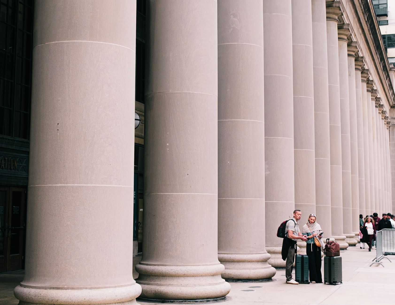 exterior of a federal courthouse building with wide stone steps and classical columns, shot from street level on a clear day