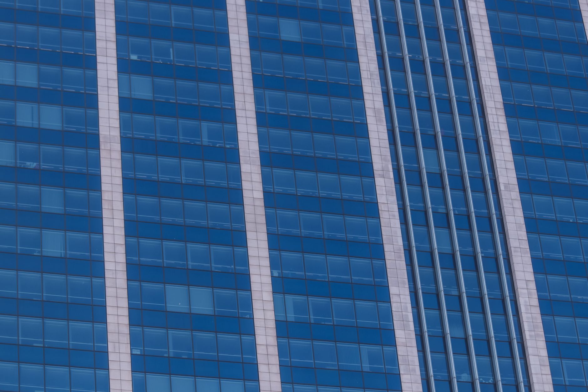 exterior of a modern glass-facade tech office building in Tel Aviv, empty lobby visible through ground-floor windows, midday light, no signage text legible
