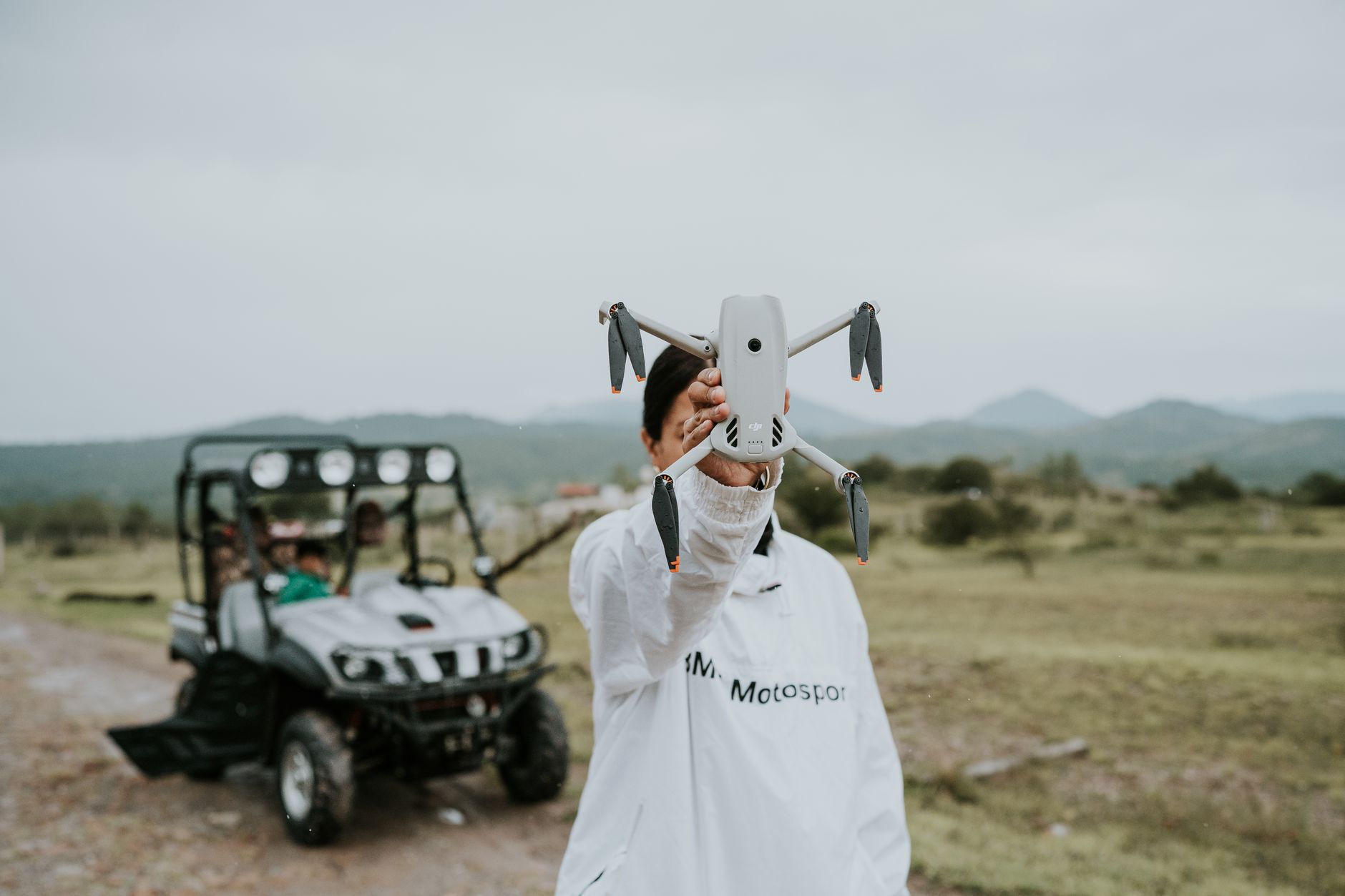 an outdoor counter-drone test range with radar arrays and a small fixed-wing interceptor drone mounted on a launch rail, set against an overcast sky